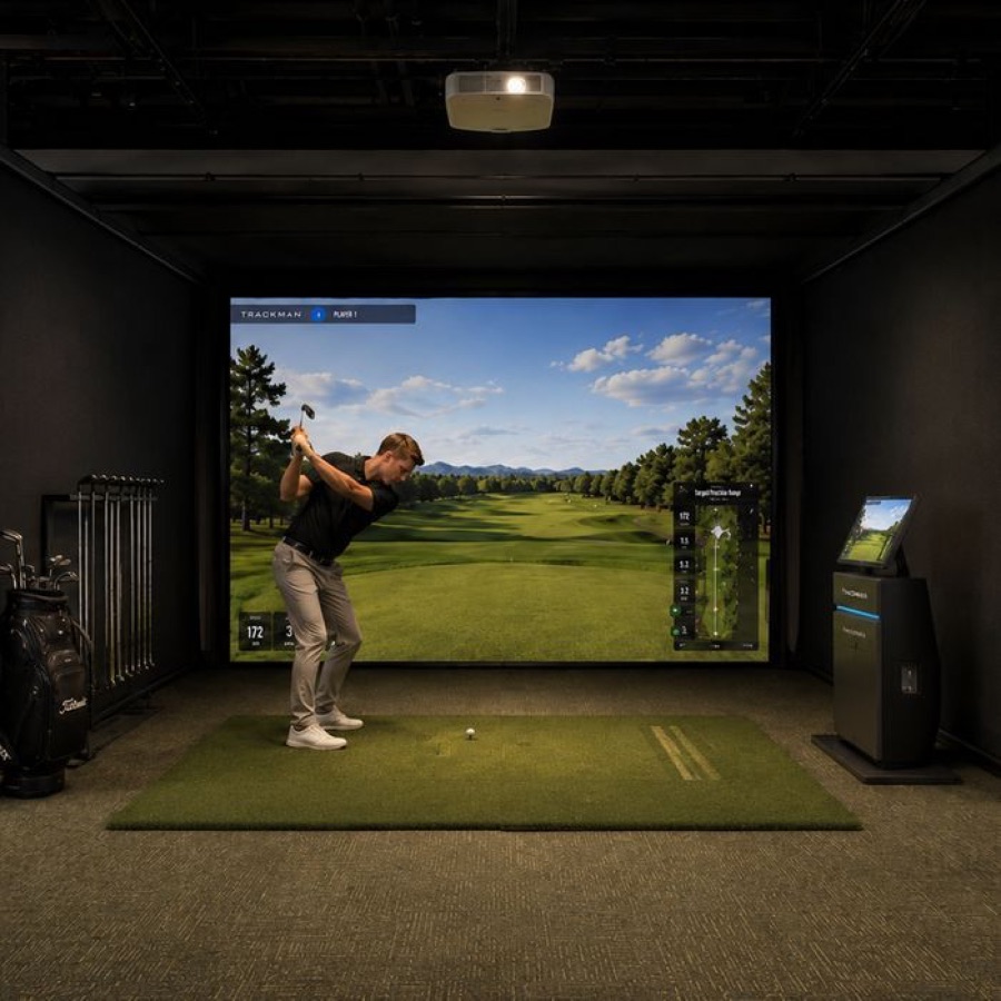 A golfer mid-swing in the indoor simulator bay